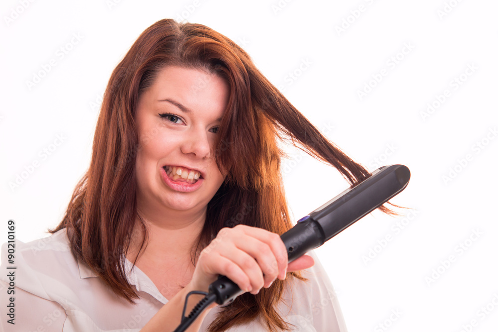 Fototapeta premium Woman tries to straighten hair