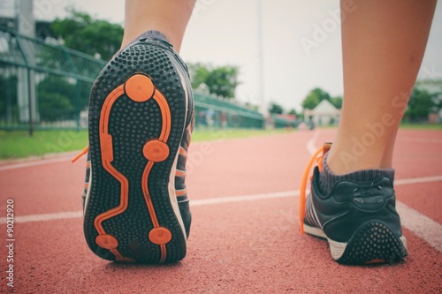 Woman with shoes running on track