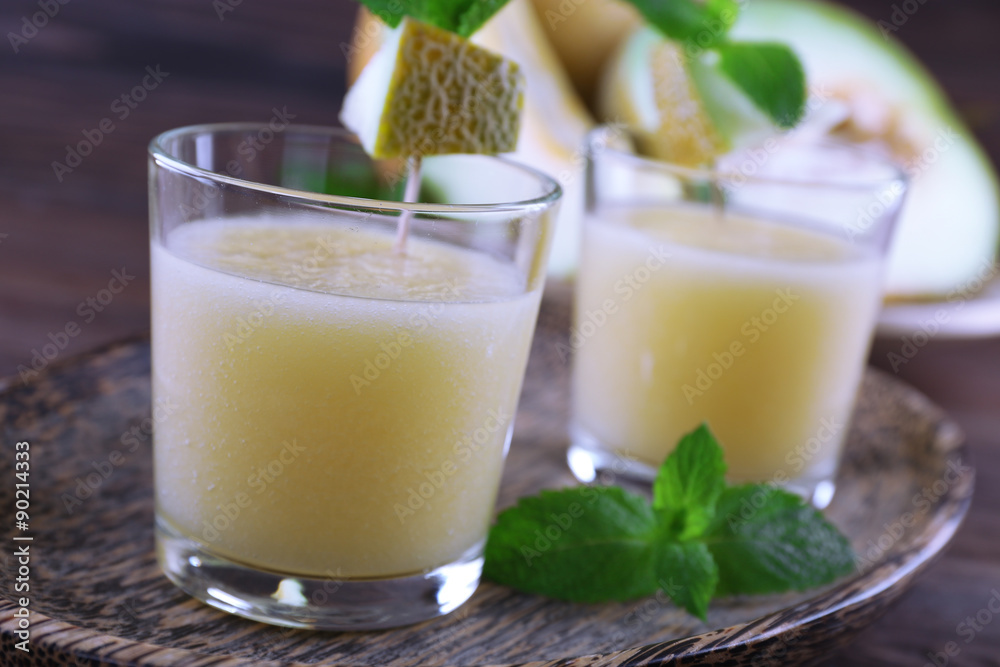 Glasses of melon cocktail on wooden tray, closeup Glasses of melon cocktail on wooden tray, closeup