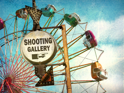 aged and worn vintage photo of shooting gallery sign at carnival