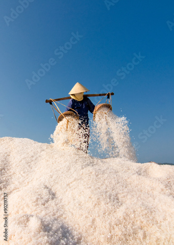 Women collecting salt from the farm in traditional industry practice in Hon Khoi, Nha Trang, Vietnam