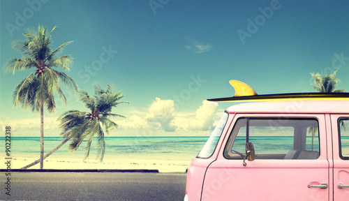 Vintage car in the beach with a surfboard on the roof