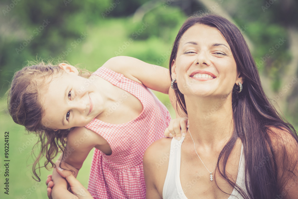 Happy mother and daughter playing in the park at the day time. Happy mother and daughter playing in the park at the day time.