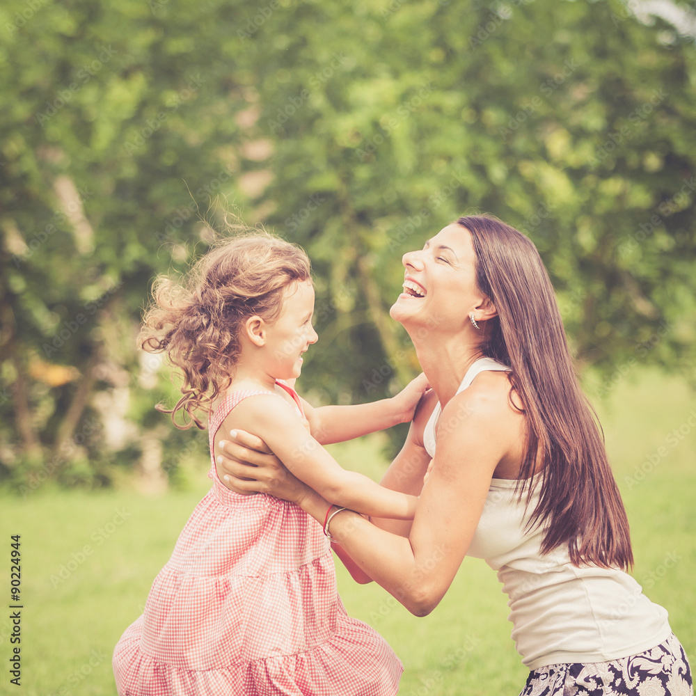 Happy mother and daughter playing in the park at the day time. Happy mother and daughter playing in the park at the day time.