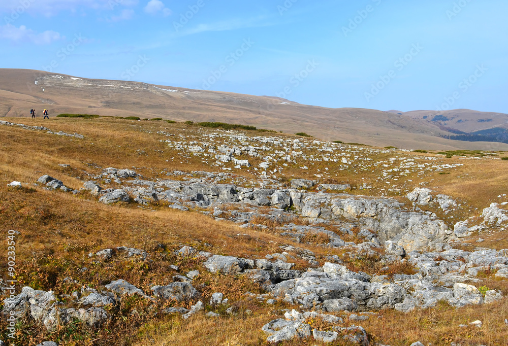 Tourists walk on a ridge Stone Sea. Lagonacky plateau in the Caucasian Biosphere Reserve, Adygeya, Russia. Tourists walk on a ridge Stone Sea. Lagonacky plateau in the Caucasian Biosphere Reserve, Adygeya, Russia.