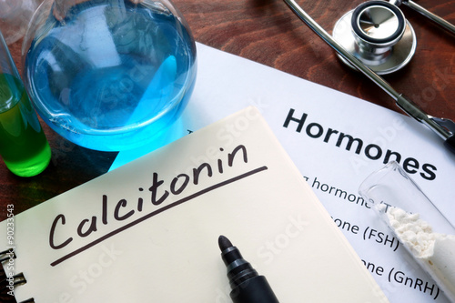 Hormone calcitonin  written on notebook. Test tubes and hormones list. photo