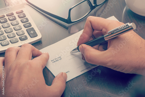 Man writing a payment cheque photo