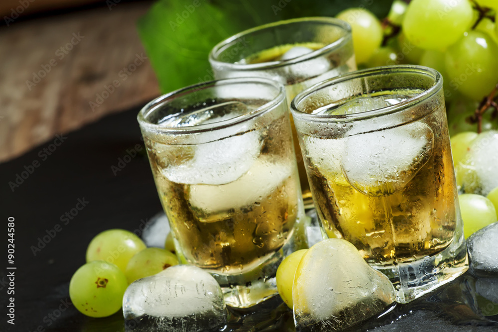Cold grape juice with ice on dark background, selective focus Cold grape juice with ice on dark background, selective focus