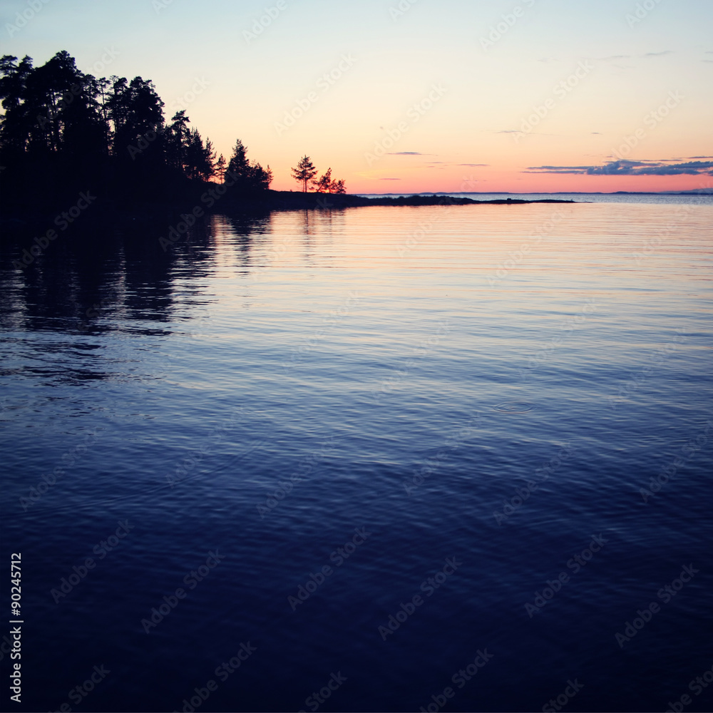 Wild nature of Russian North. Sunset. Lake and trees.