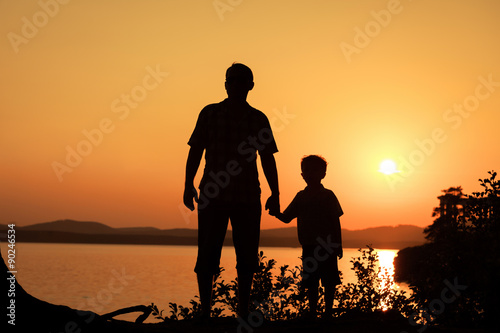 father and son playing on the coast of lake © altanaka