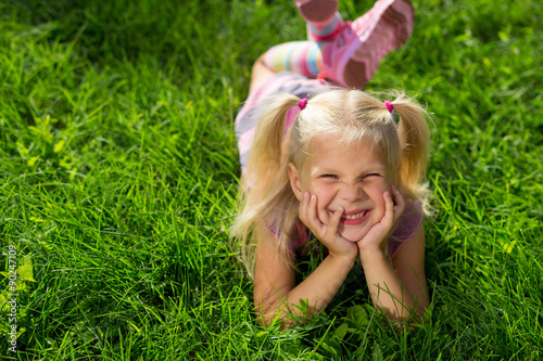 little girl lying on the grass and laughing