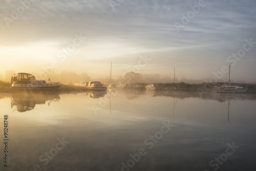 Stunning foggy Summer sunrise over peaceful river landscape in E