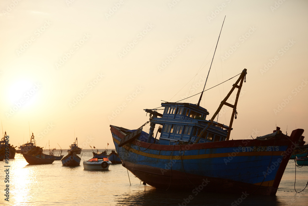 fishing boats in the sea at sunset