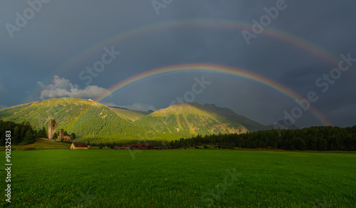Real full double rainbow in a mountain meadow photo
