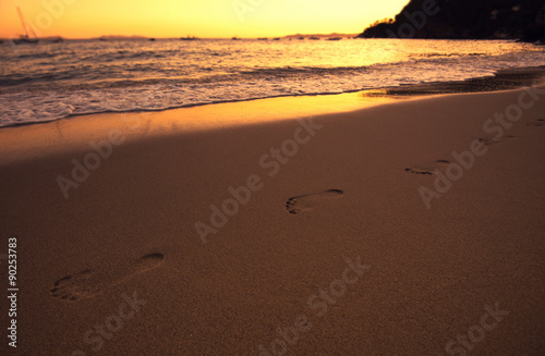 Empreinte de pas sur le sable au bord de l'eau