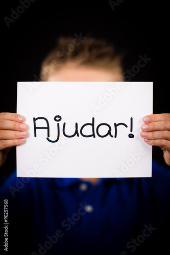 Child holding sign with Portuguese word Ajudar - Help