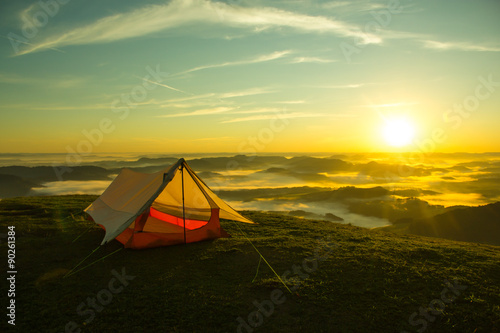 Tent on the top of a mountain with the sunrise