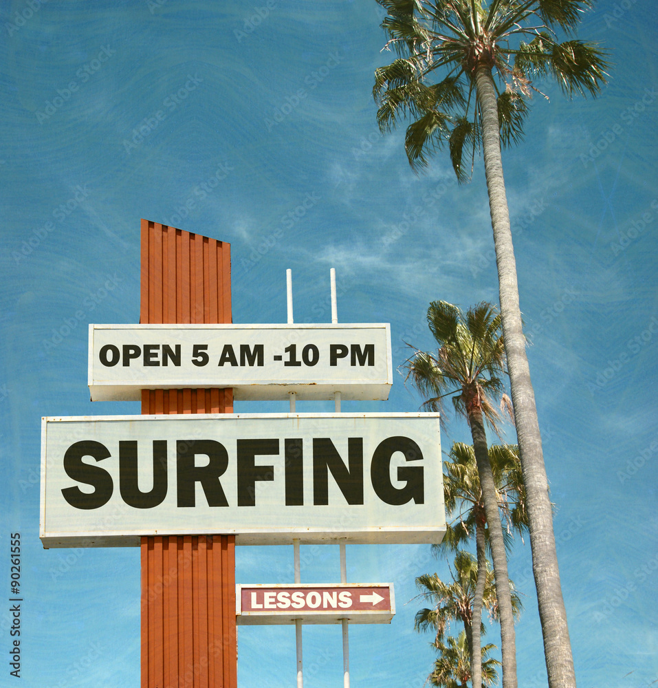 aged and worn vintage photo of surfing sign and palm trees