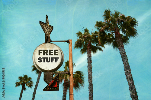 aged and worn vintage photo of free sign with palm trees