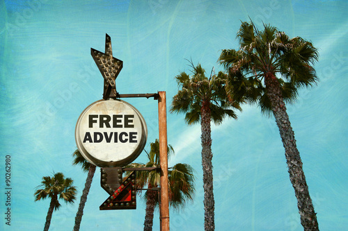 aged and worn vintage photo of free advice sign with palm trees