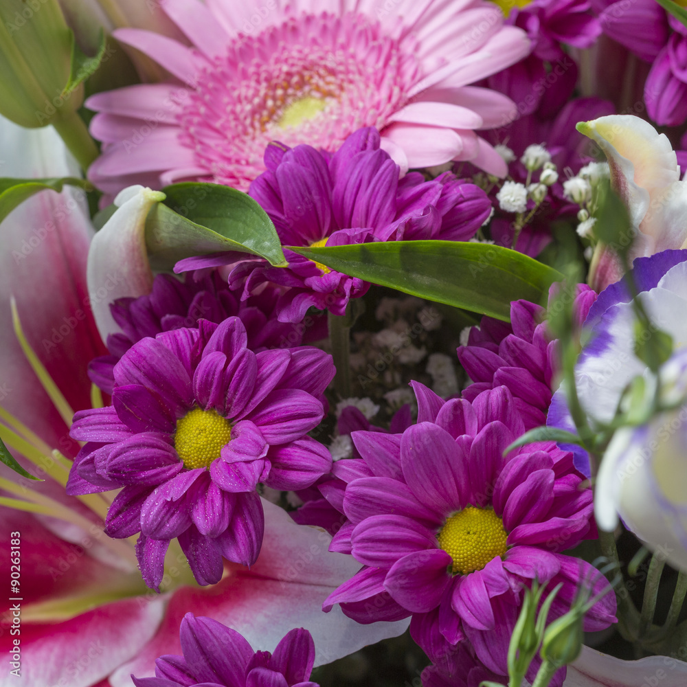 Obraz premium Flower bouquet close up with purple flowers and green leaves