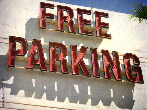 aged and worn vintage photo of neon free parking sign © jdoms