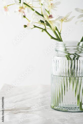 Fototapeta Naklejka Na Ścianę i Meble -  Close up of orchids flowers in a vintage glass vase