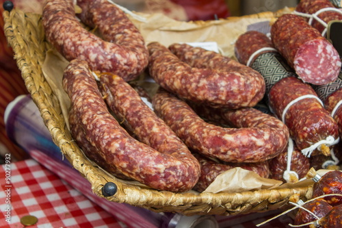 Freshly prepared raw sausage in basket on stall