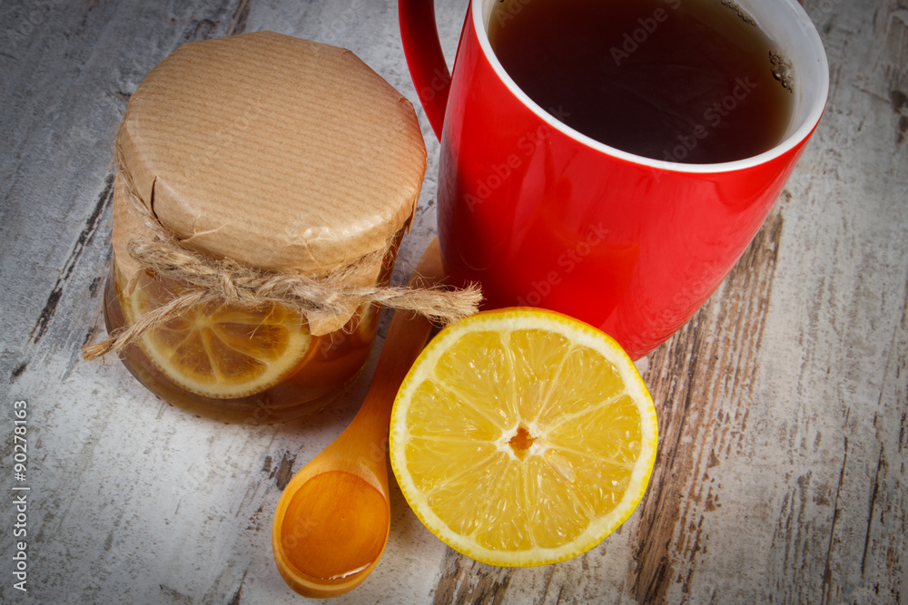 Lemon with honey and cup of tea on wooden table, healthy nutrition Lemon with honey and cup of tea on wooden table, healthy nutrition