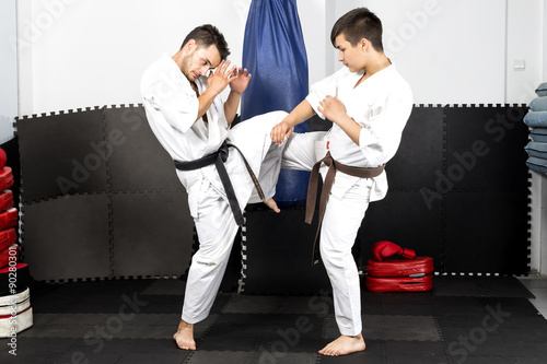 Two young men in kimono fighting- ashihara karate-during their t