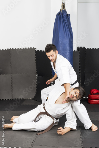 Two young men in kimono fighting- ashihara karate-during their t photo