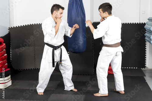 Two young men in kimono fighting- ashihara karate-during their t photo