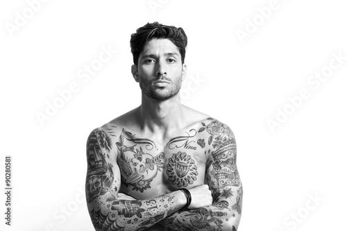 Sexy tattooed man portrait with crossed arms black and white