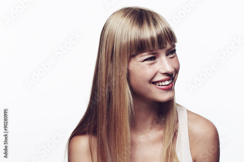 Happy and smiling young blond woman in studio