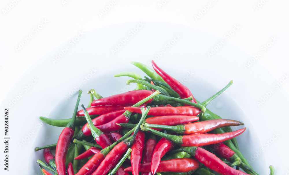 Red and green chilli on white dish Red and green chilli on white dish
