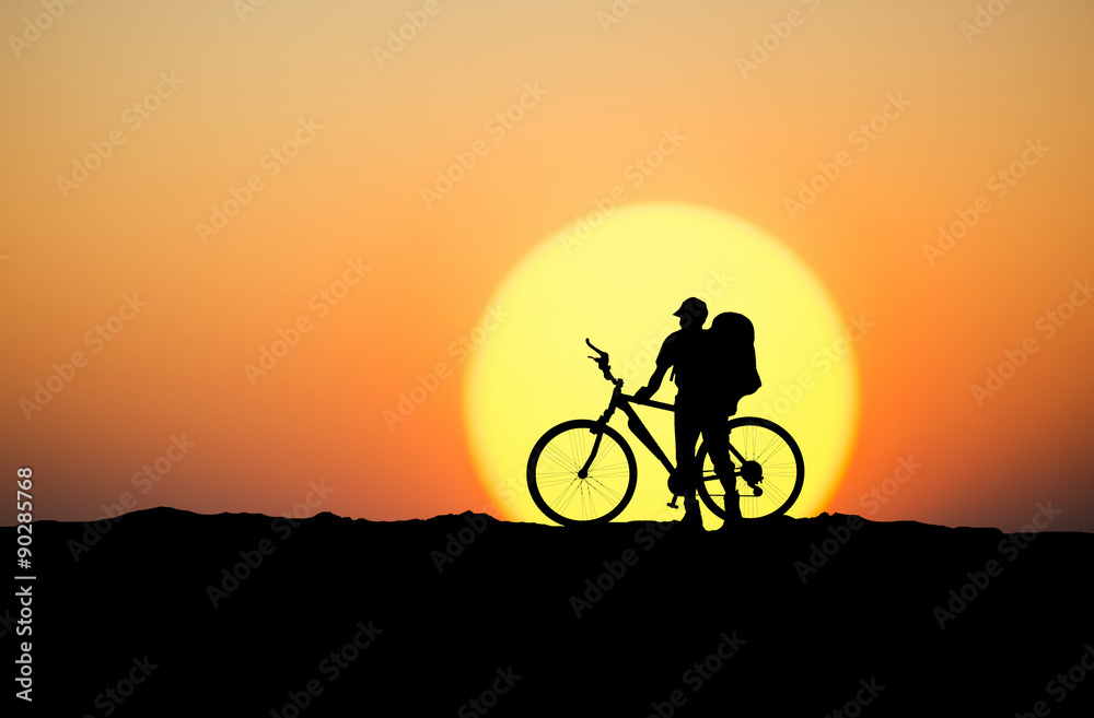 Silhouette of a biker on the mountain top. Sport and active life concept..