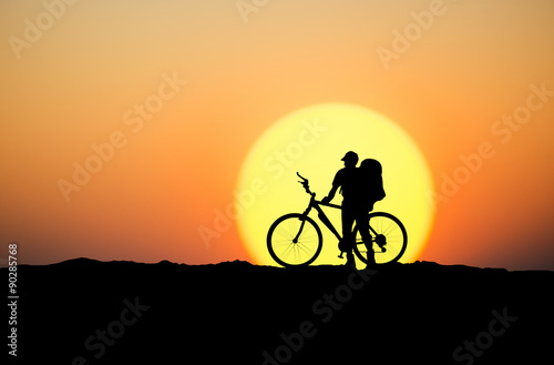 Silhouette of a biker on the mountain top. Sport and active life concept..