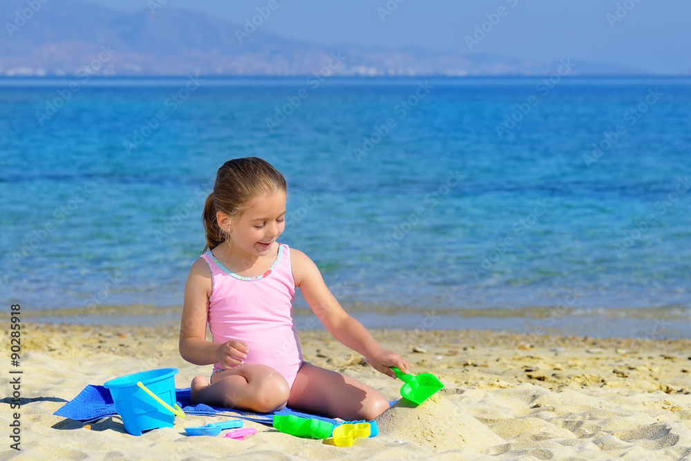 Adorable toddler girl playing with her toys at the beach Adorable toddler girl playing with her toys at the beach