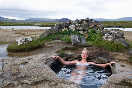 Young woman in natural hot spring in Iceland