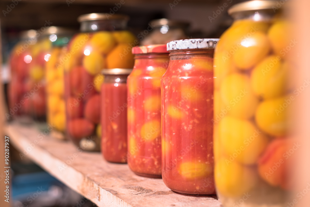 Pickled Canned Tomatoes in a Raw on the Wooden Shelf Pickled Canned Tomatoes in a Raw on the Wooden Shelf