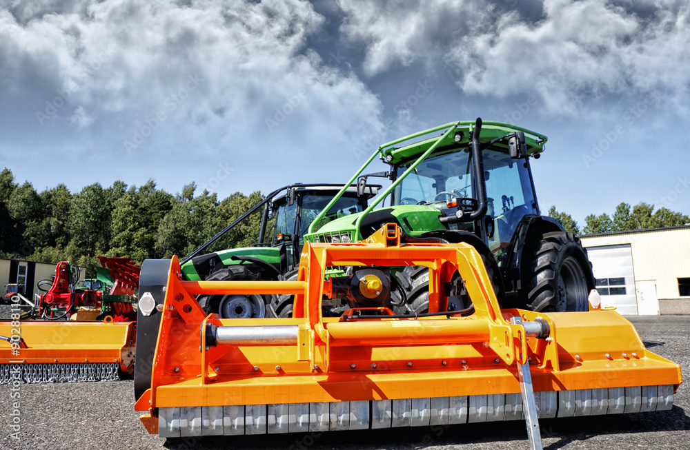 giant plow and mower coupled to a farming tractor, latest models