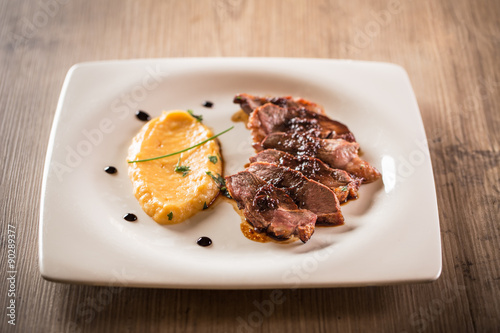 Duck magret on a wooden table.