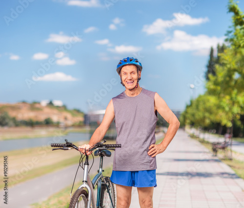 Active senior biker posing on a sidewalk