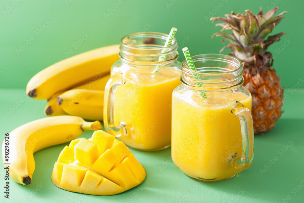 healthy yellow smoothie with mango pineapple banana in mason jar