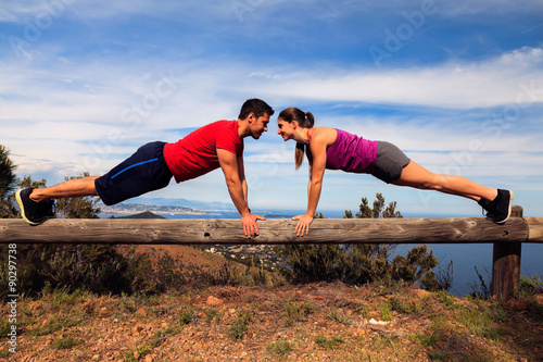 A man and a woman doing push-ups