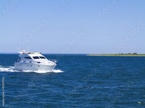 Weiße moderne Motoryacht mit Meer und Insel © Wilm Ihlenfeld