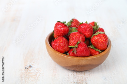 Ripe strawberries in a brown bowl