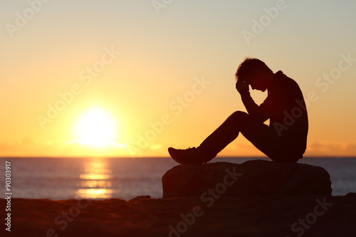 фотографія Sad man silhouette worried on the beach