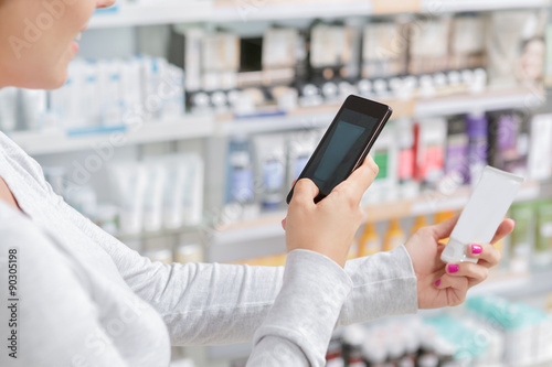 Close up a woman taking picture of product in drugstore