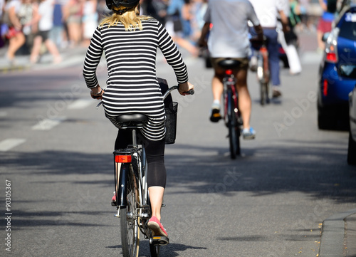 Blonde woman with helmet on bike in traffic